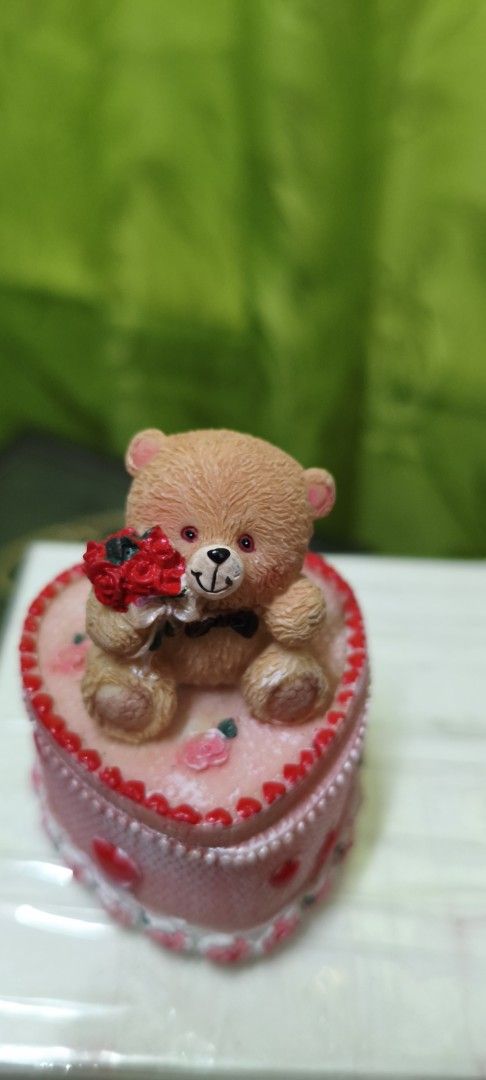 Cute Teddy Bear with Roses on Heart-Shaped Box (Category: Plushies & Soft Toys) located in Quezon City. Submitted by gemaicloset (Listing ID 1462684070, Image 1). Description: - Adorable teddy bear figurine - Holding a bouquet of red roses - Sits on a pink heart-shaped box - Box features decorative red hearts and pink roses - Ideal for gifting or as a cute decor piece - Perfect for Valentine's Day or any special occasion.