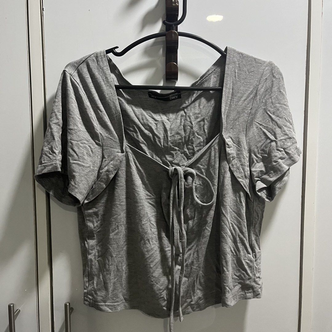 Dazy Grey Square Neck Tie Front Crop Top (Category: Blouses) located in Manila. Submitted by 4ngeluh (Listing ID 1462684176, Image 1). Description: - Grey crop top from Dazy - Features a square neckline with a tie front detail - Short sleeves - Versatile for styling with jeans or skirts - Ideal for casual wear.