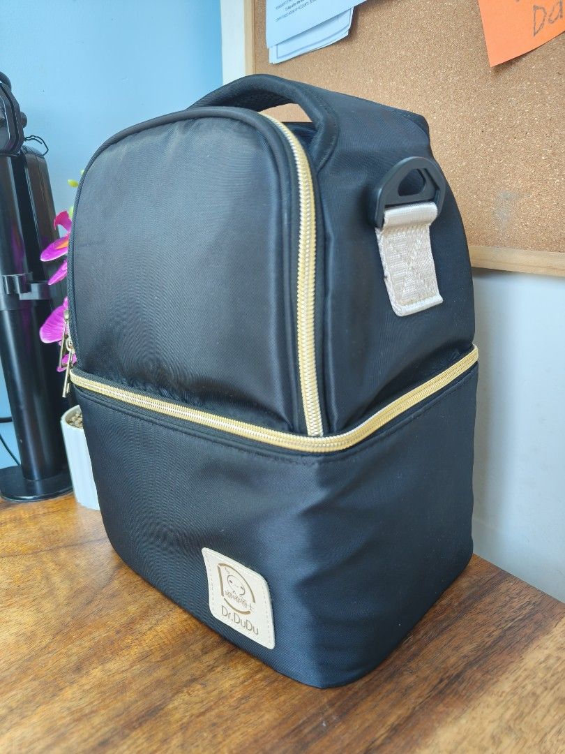 Dr. Dudu Black Insulated Cooler Bag (Category: Breastfeeding & Bottle Feeding) located in Antipolo. Submitted by momshieanj (Listing ID 1462833377, Image 1). Description: - Brand: Dr. Dudu - Color: Black - Features: Insulated main compartment, front zip pocket - Material: Durable nylon exterior - Hardware: Gold zippers - Carrying Options: Top handle, hanging loop - Ideal for: Keeping food/drinks cool during outings or travel.