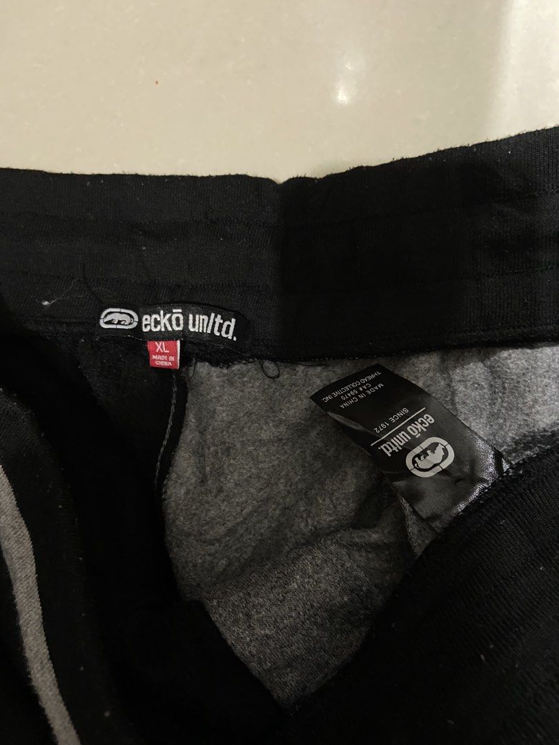 Ecko Unltd. Split Color Sweat Shorts XL (Category: Shorts) located in Cavite. Submitted by hail1530 (Listing ID 1462831798, Image 2). Description: - Ecko Unltd. shorts in XL size. - Stylish black and grey split design. - Features Ecko Unltd. logo on black side. - 'World Famous 1972' graphic on grey side. - Comfortable elastic waistband with drawstring. - Two convenient side pockets. - Ideal for everyday casual wear..