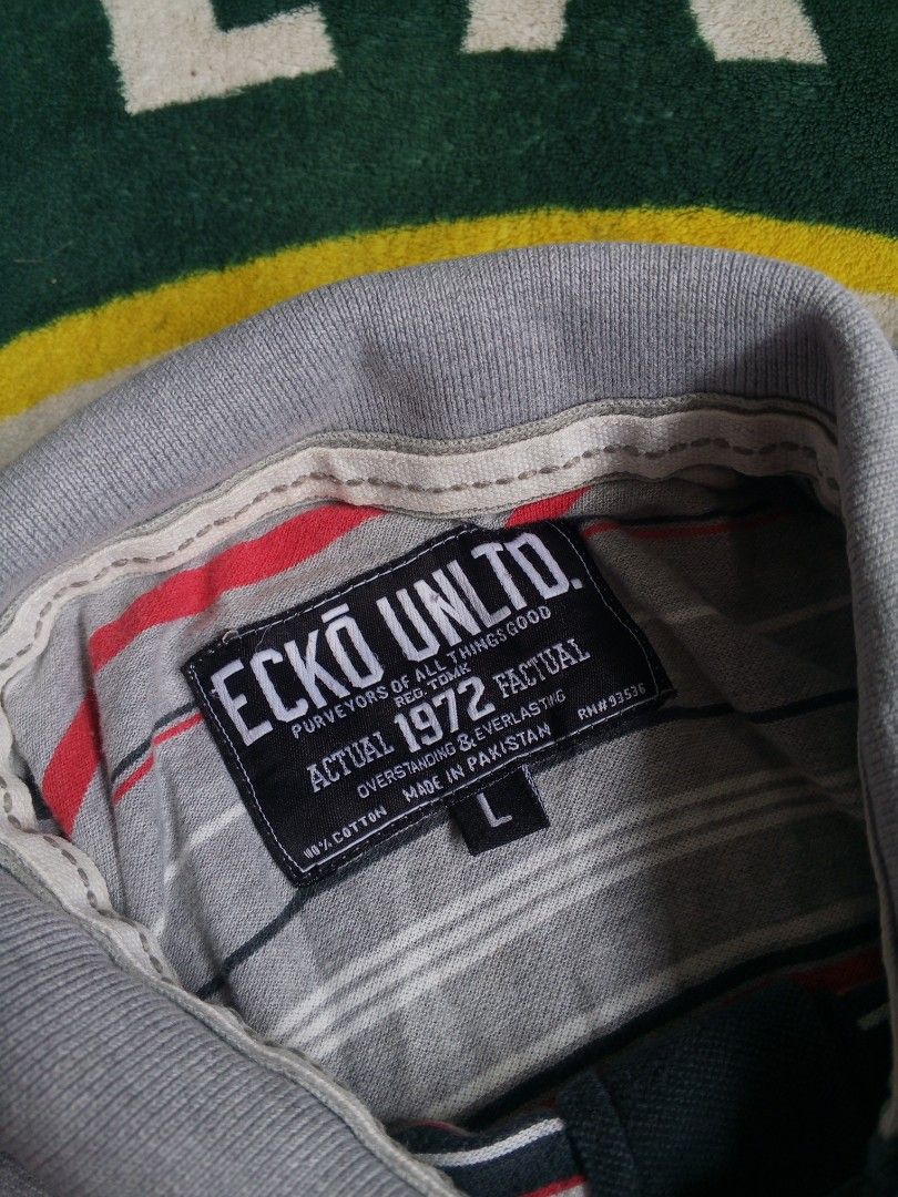 Ecko Unltd. Striped Polo Shirt Size L (Category: Tshirts & Polo Shirts ) located in Las Pinas. Submitted by allhandpick (Listing ID 1462865484, Image 3). Description: - Brand: Ecko Unltd. - Color: Grey with red, white, and navy stripes - Material: 100% Cotton - Tag detail: 'Actual 1972 Factual' - Style: Casual wear.
