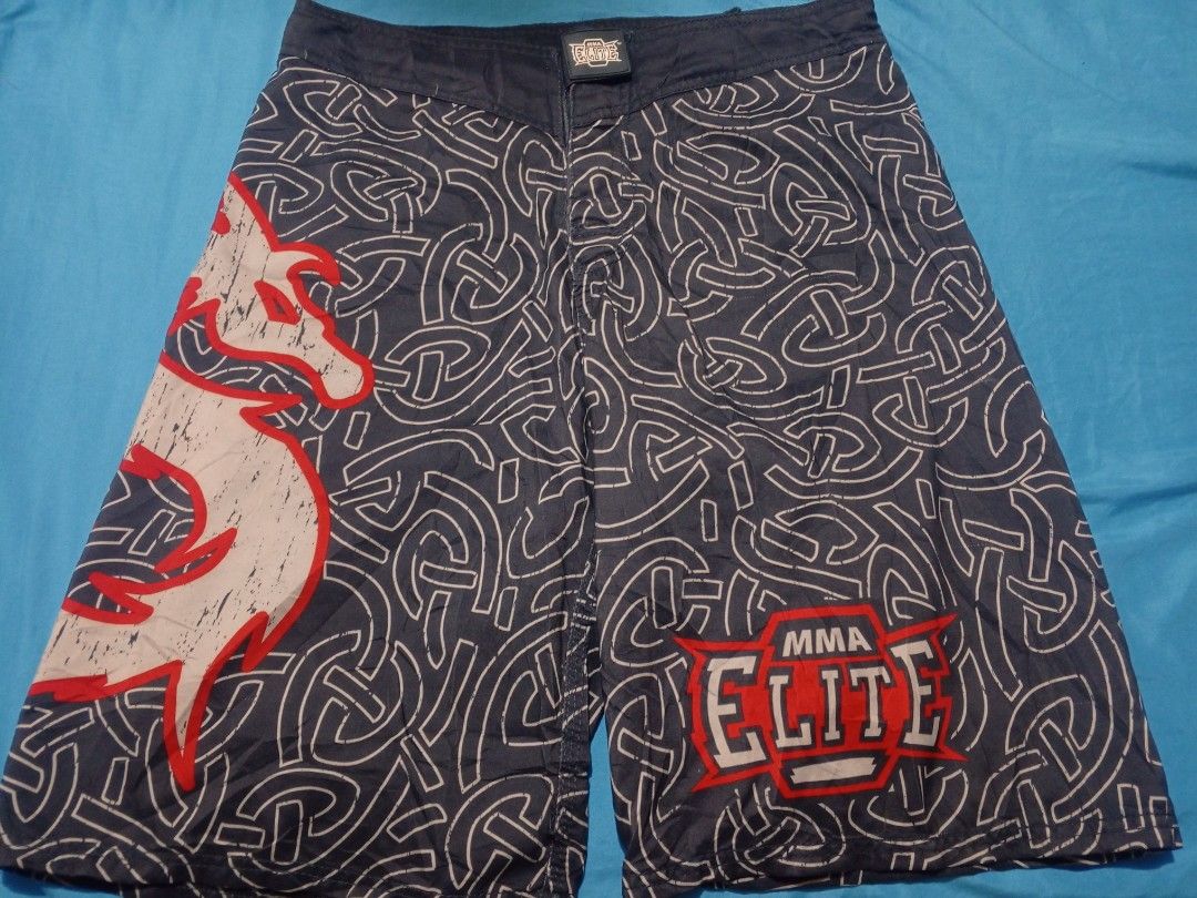 Elite MMA Fight Shorts Size Medium (Category: Shorts) located in Baguio. Submitted by musashinz (Listing ID 1462820645, Image 1). Description: - Elite MMA fight shorts - Size: Medium - Color: Dark grey - Design: White and red Celtic knot pattern - Graphics: Large white and red wolf graphic (left leg), Elite MMA logo (right leg) - Ideal for: Training or casual wear.