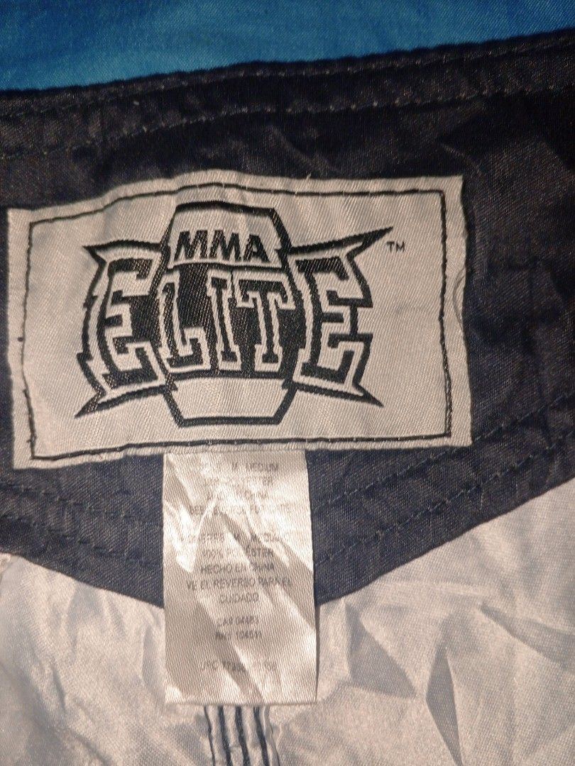 Elite MMA Fight Shorts Size Medium (Category: Shorts) located in Baguio. Submitted by musashinz (Listing ID 1462820645, Image 3). Description: - Elite MMA fight shorts - Size: Medium - Color: Dark grey - Design: White and red Celtic knot pattern - Graphics: Large white and red wolf graphic (left leg), Elite MMA logo (right leg) - Ideal for: Training or casual wear.