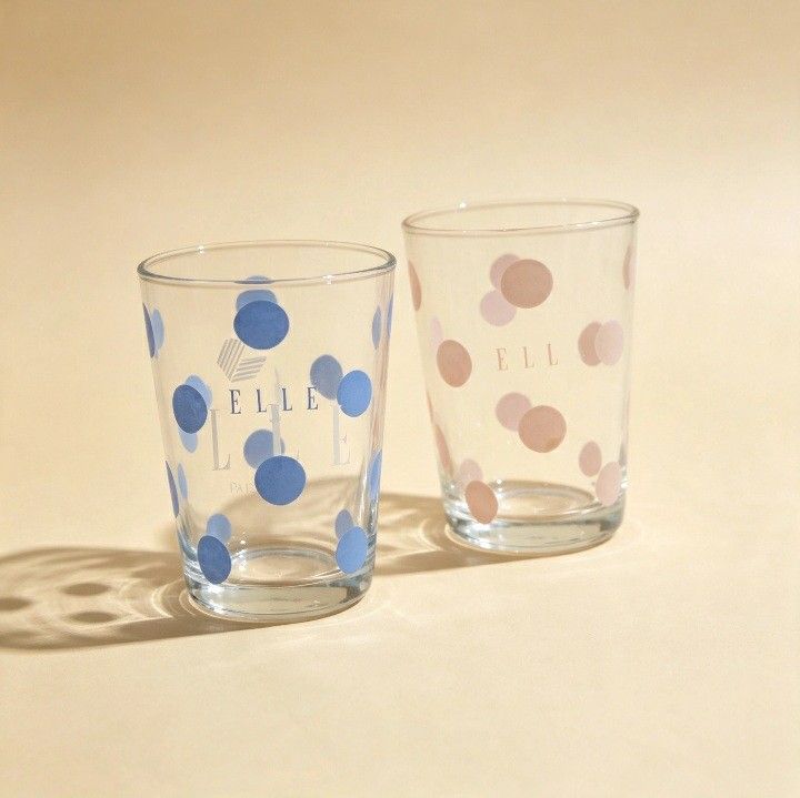 ELLE Paris Polka Dot Drinking Glasses Set (Category: Dinnerware & Cutlery) located in Iligan City. Submitted by sariranaw (Listing ID 1462880901, Image 2). Description: - Set of two (2) ELLE Paris glasses. - One glass features a blue polka dot design. - The other glass features a pink polka dot design. - Both glasses have the iconic ELLE logo printed on them. - Ideal for everyday use, serving water, juice, or other beverages. - Makes a charming a