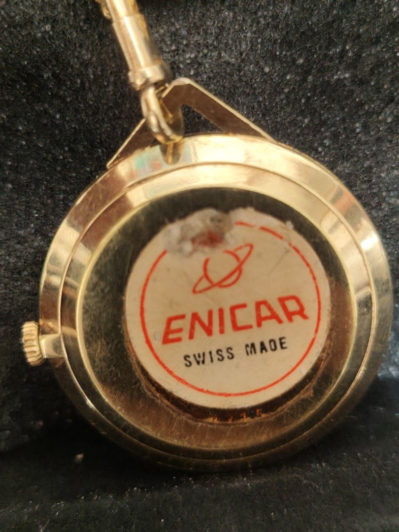 Enicar (Swiss, vintage) (Category: Luxury Watches) located in Bacolod City. Submitted by john0000007 (Listing ID 1462706078, Image 2). Description: Brand: Enicar (Swiss, vintage) Type: Pocket Watch / Pendant Watch — Star Jewels series, date window at 3 o'clock Era: 1960s–1970s, Swiss-made mechanical hand-wind movement Key Details: - Case: Gold-plated, round ~40–42mm diameter - Dial: Gold sunburst, baton hour markers, date at 3 o'clock - Markings: