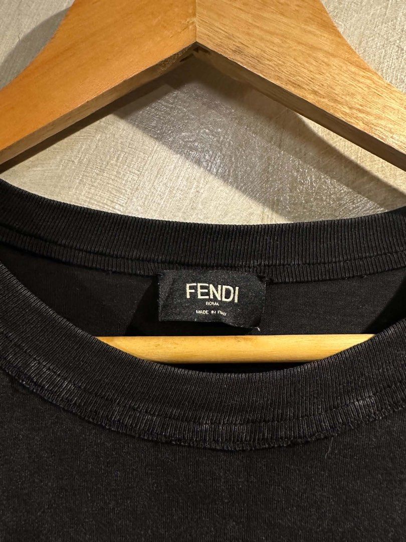 Fendi Roma T-Shirt Size M (Category: Tshirts & Polo Shirts ) located in Manila. Submitted by salaspasio80393 (Listing ID 1462755611, Image 2). Description: - Authentic Fendi Roma T-shirt - Color: Black (washed-out look) - Size: Medium (M) - Material: 100% Cotton - Made in Italy - Features a small Fendi logo on the front - Condition: Small tear near the bottom hem (refer to last photo) - Sold as is.