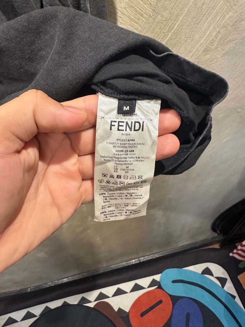 Fendi Roma T-Shirt Size M (Category: Tshirts & Polo Shirts ) located in Manila. Submitted by salaspasio80393 (Listing ID 1462755611, Image 3). Description: - Authentic Fendi Roma T-shirt - Color: Black (washed-out look) - Size: Medium (M) - Material: 100% Cotton - Made in Italy - Features a small Fendi logo on the front - Condition: Small tear near the bottom hem (refer to last photo) - Sold as is.