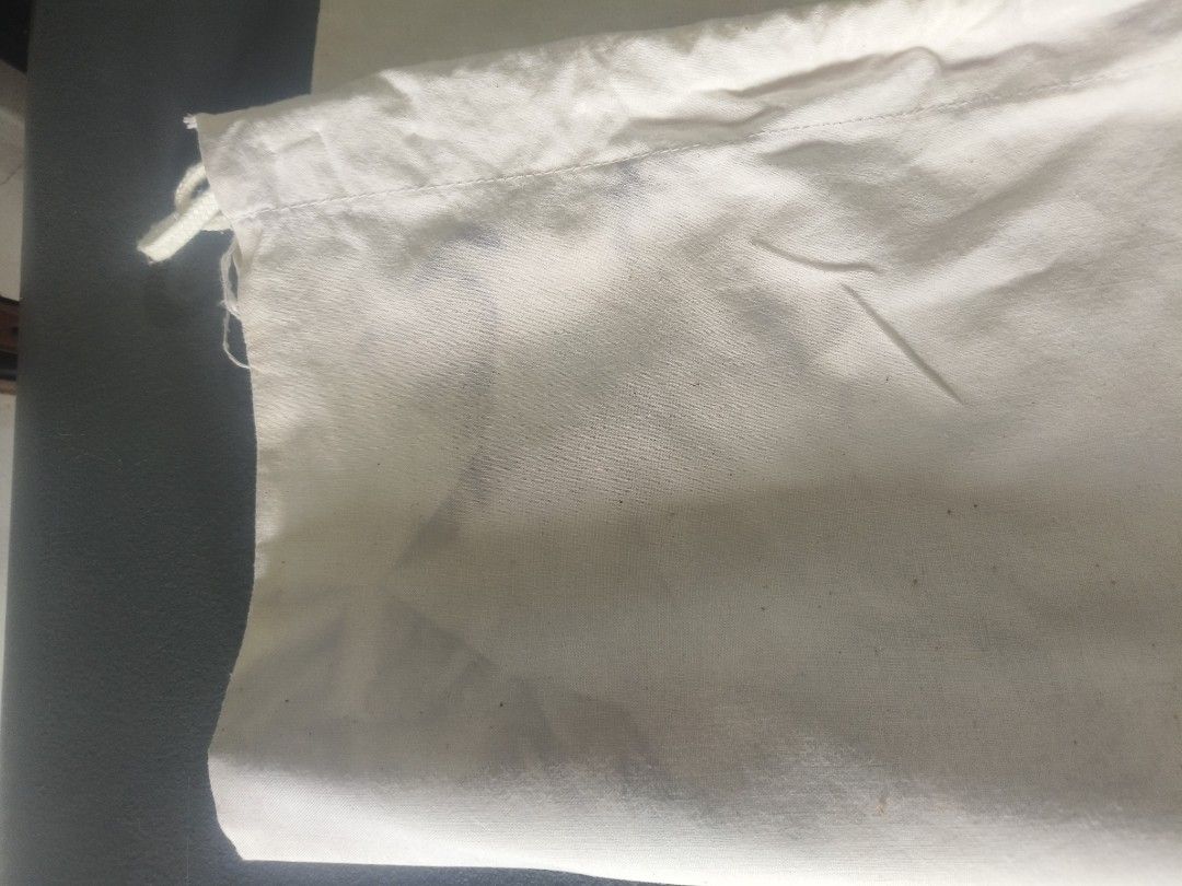 Fiorucci Safety Jeans Italy Drawstring Dust Bag (Category: Luxury Bags & Wallets) located in San Jose del Monte. Submitted by m_nshop (Listing ID 1462709773, Image 3). Description: - White drawstring bag with iconic Fiorucci cherub graphic. - Features 'Fiorucci Safety Jeans Italy' text. - Dual drawstrings for secure closure. - Approximately 18 inches wide. - Perfect for storage or as a stylish casual carry-all. with sign of usage needs cleaning a
