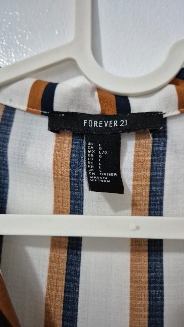 Forever 21 Striped Long Sleeve Shirt (Category: Longsleeves) located in Pasig City. Submitted by magnoliafern (Listing ID 1462816101, Image 2). Description: - Forever 21 long sleeve shirt - Classic stripe pattern: white, navy, and rust - Button-up front - Chest pocket - Material: 100% polyester - Ideal for casual outfits or layering.