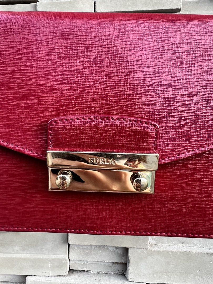 Furla Red Leather Chain Convertible Bag (Category: Luxury Bags & Wallets) located in San Jose. Submitted by jorelleah (Listing ID 1462810746, Image 2). Description: - Classic Furla Metropolis red leather convertible - Features a gold-tone clasp closure with Furla logo - Stylish chain strap detail - Ideal for evening events or adding a pop of color - Can fit long wallet.