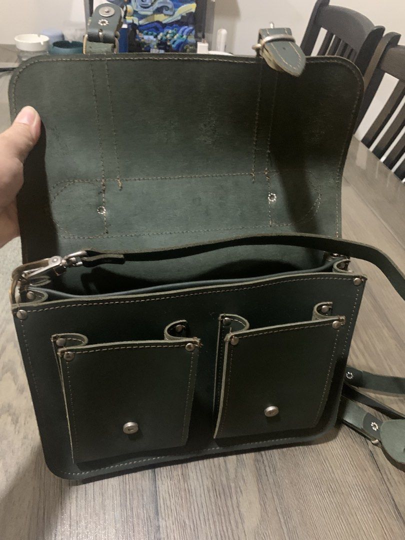 GRAFEA Leather Satchel Bag - Made in England (Category: Luxury Bags & Wallets) located in Mandaluyong City. Submitted by lgariba (Listing ID 1462718636, Image 2). Description: - Classic dark green leather satchel from GRAFEA - Handcrafted in England - Top handle and detachable shoulder strap - Multiple interior compartments - Two convenient front pockets - Secure buckle closures - Ideal for work or everyday carry.