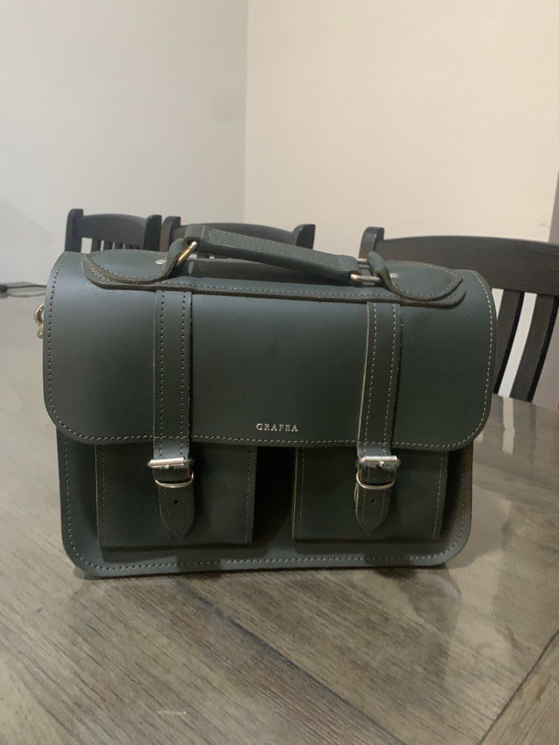 GRAFEA Leather Satchel Bag - Made in England (Category: Luxury Bags & Wallets) located in Mandaluyong City. Submitted by lgariba (Listing ID 1462718636, Image 1). Description: - Classic dark green leather satchel from GRAFEA - Handcrafted in England - Top handle and detachable shoulder strap - Multiple interior compartments - Two convenient front pockets - Secure buckle closures - Ideal for work or everyday carry.