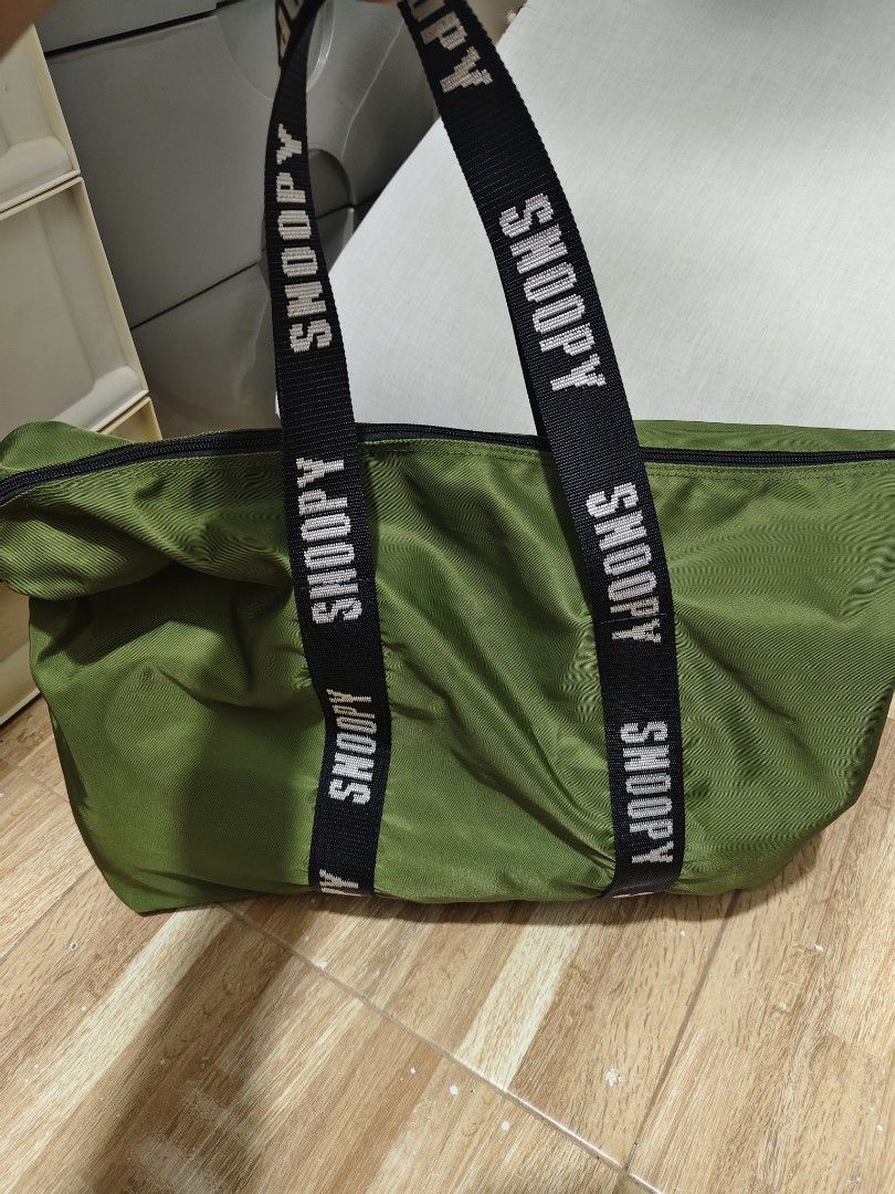 Green Snoopy Duffel Bag with Black Straps (Category: Cross-body Bags) located in Makati City. Submitted by abegailbrezuela (Listing ID 1462783816, Image 3). Description: - Cool green duffel bag with Snoopy branding on straps. - Convenient zippered side pocket. - Spacious main compartment for all your essentials. - Durable material, built to last. - Ideal for weekend trips or gym sessions. - Ready for its next adventure!.