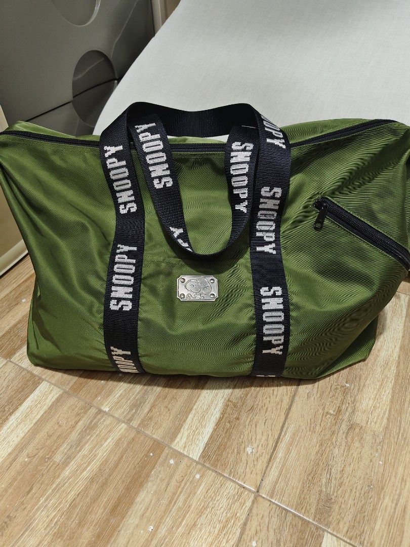 Green Snoopy Duffel Bag with Black Straps (Category: Cross-body Bags) located in Makati City. Submitted by abegailbrezuela (Listing ID 1462783816, Image 2). Description: - Cool green duffel bag with Snoopy branding on straps. - Convenient zippered side pocket. - Spacious main compartment for all your essentials. - Durable material, built to last. - Ideal for weekend trips or gym sessions. - Ready for its next adventure!.