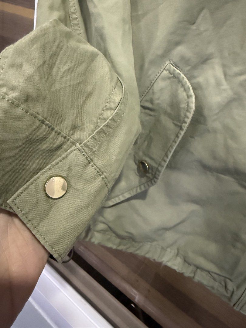 GU mountain parka (Category: Coats, Jackets and Outerwear) located in Manila. Submitted by kristinata44809 (Listing ID 1462881399, Image 2). Description: - Lightweight green jacket from GU - Features a hood - Drawstring waist for adjustable fit - Two front pockets with button closure - Button and zip front closure - Ideal for layering and casual outfits.
