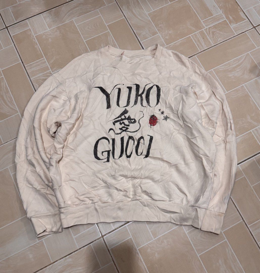 Gucci Yuko Sweatshirt (Category: Longsleeves) located in Alaminos. Submitted by outfitcheck.ph (Listing ID 1462818165, Image 1). Description: - Cream colored sweatshirt - Features 'Yuko Gucci' graphic print on the front - Adorned with a small red ladybug and star details - Long sleeves and crew neck design - Ideal for casual wear - Please check photos for condition details.