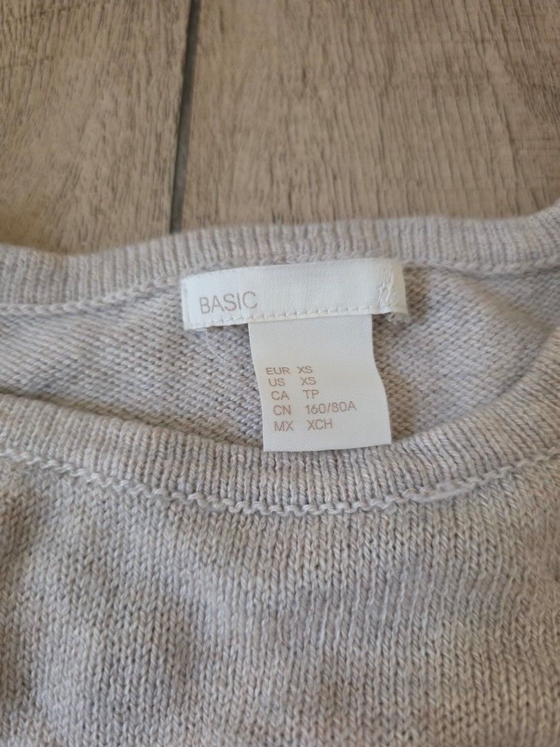 H&M Beige raglan sleeve sweater (Category: Longsleeves) located in Quezon City. Submitted by preloved_by_mariekondo (Listing ID 1462756372, Image 2). Description: Light beige or oat melange knit sweater from H&M featuring signature raglan sleeves, a classic crew neckline, and casual, slightly curled or raw edges on the hem and cuffs. Size XS (loose fitting).