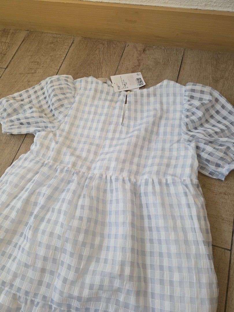 H&M blue checkered dress (Category: Babies & Kids Fashion) located in Quezon City. Submitted by preloved_by_mariekondo (Listing ID 1462780732, Image 3). Description: H&M Signature sheer, puckered seersucker gingham pattern, a delicate buttoned keyhole back closure, and short elasticated balloon sleeves. Size 128 fits 7-8Y runs slightly big.