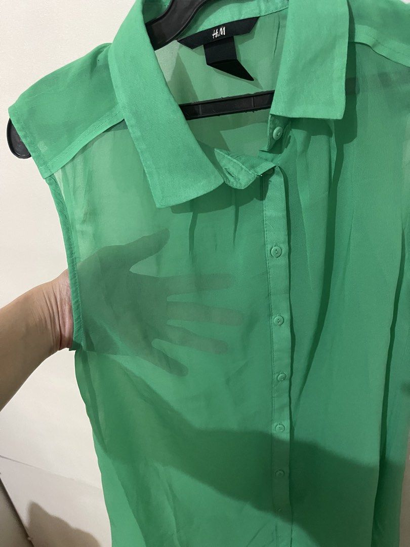 H&M Green Sleeveless Collared Shirt (Category: Sleeveless) located in Santa Cruz. Submitted by lilpurpleseven (Listing ID 1462700144, Image 3). Description: - H&M green sleeveless shirt - Button-up front with collared neckline - Sheer material (camisole recommended) - Slightly longer hem at the back - Versatile for layering or wearing alone.
