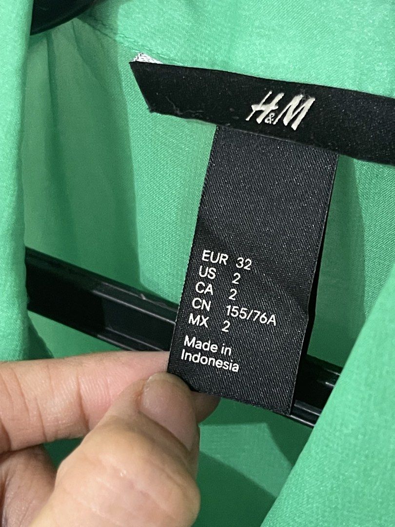 H&M Green Sleeveless Collared Shirt (Category: Sleeveless) located in Santa Cruz. Submitted by lilpurpleseven (Listing ID 1462700144, Image 2). Description: - H&M green sleeveless shirt - Button-up front with collared neckline - Sheer material (camisole recommended) - Slightly longer hem at the back - Versatile for layering or wearing alone.