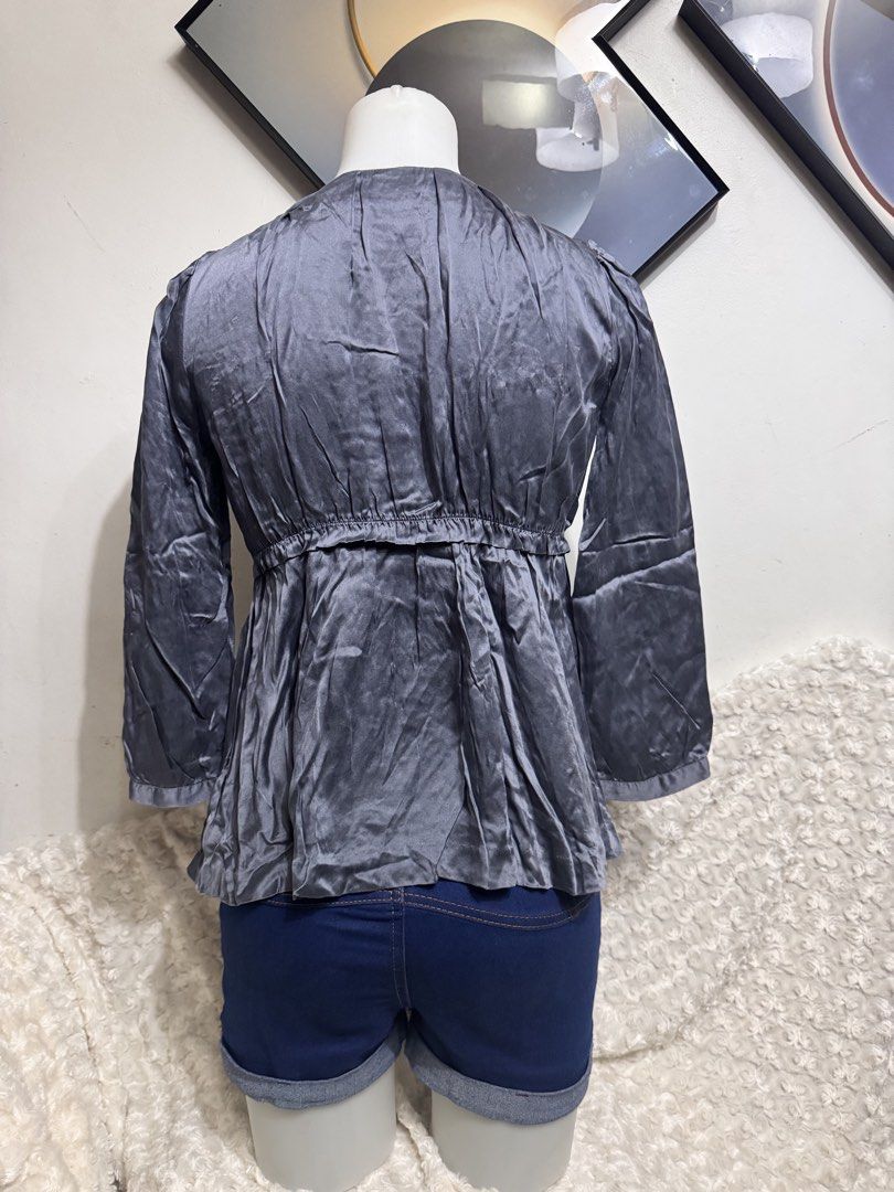 H&M Grey Satin Peplum Blouse (Category: Blouses) located in Marikina City. Submitted by lorradel (Listing ID 1462730676, Image 3). Description: - Grey satin peplum blouse from H&M - Gathered neckline with button details - Elasticated waist for a flattering fit - Three-quarter length sleeves - Perfect with jeans or shorts - Dress up or down easily - MAY HAVE some washable stains (hindi maiiwasan) needs washing; had been stored - mannequin size 34-