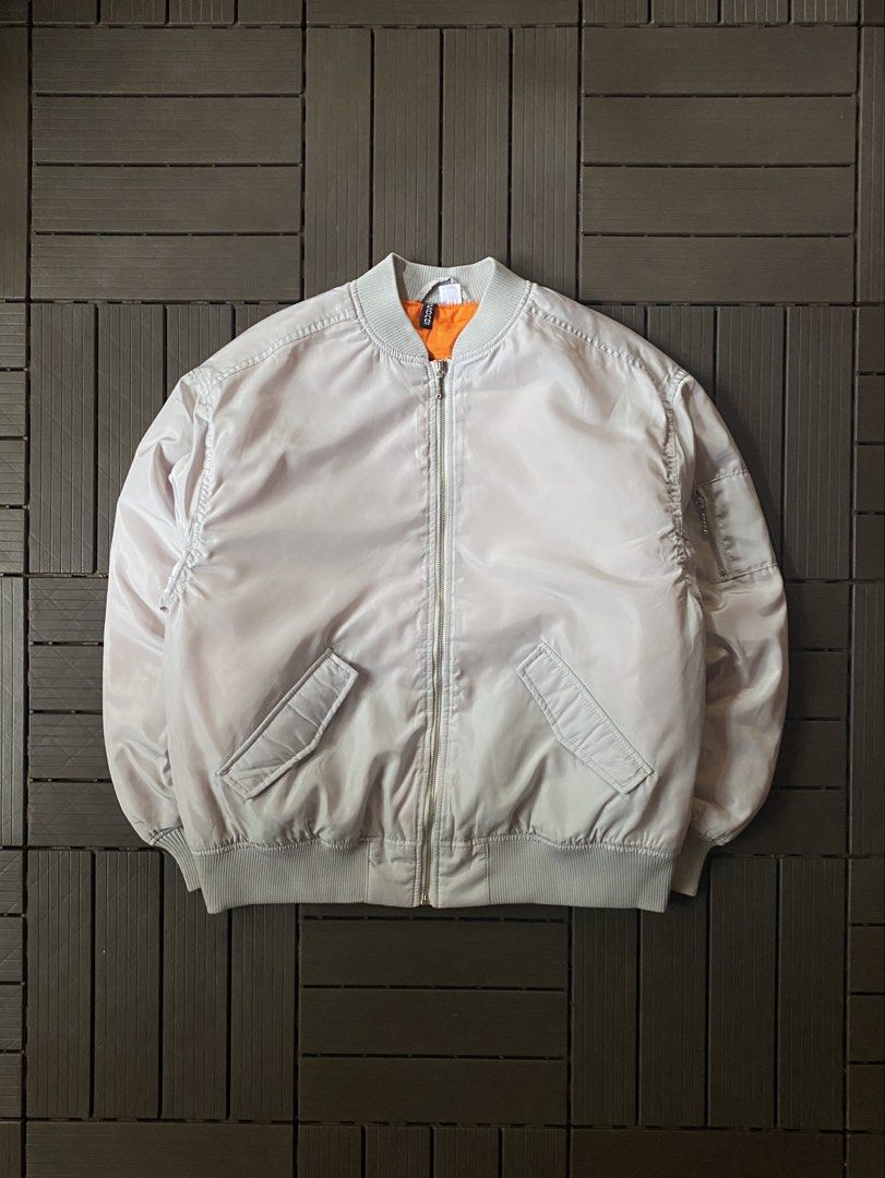 H&M Light Grey Bomber Jacket Orange Lining (Category: Coats, Jackets and Outerwear) located in Puerto Princesa. Submitted by streetnfinds (Listing ID 1462758147, Image 1). Description: Length: 25.5" Width: 22.5" Sleeve Length: 22.5" Large - Light grey bomber jacket from H&M - Features a bright orange lining - Zippered pocket on the sleeve - Ribbed collar, cuffs, and hem - Ideal for layering.