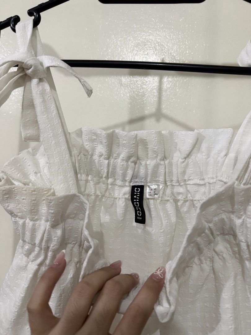H&M White Textured Tie Strap Smocked Crop Top (Category: Sleeveless) located in Manila. Submitted by lovedbyan (Listing ID 1462878839, Image 2). Description: -XS-S - White H&M crop top - Textured fabric - Smocked bust for a flattering fit - Adjustable tie shoulder straps - Super cute and summery design - Versatile: pairs well with shorts or skirts - Ideal for casual outings.