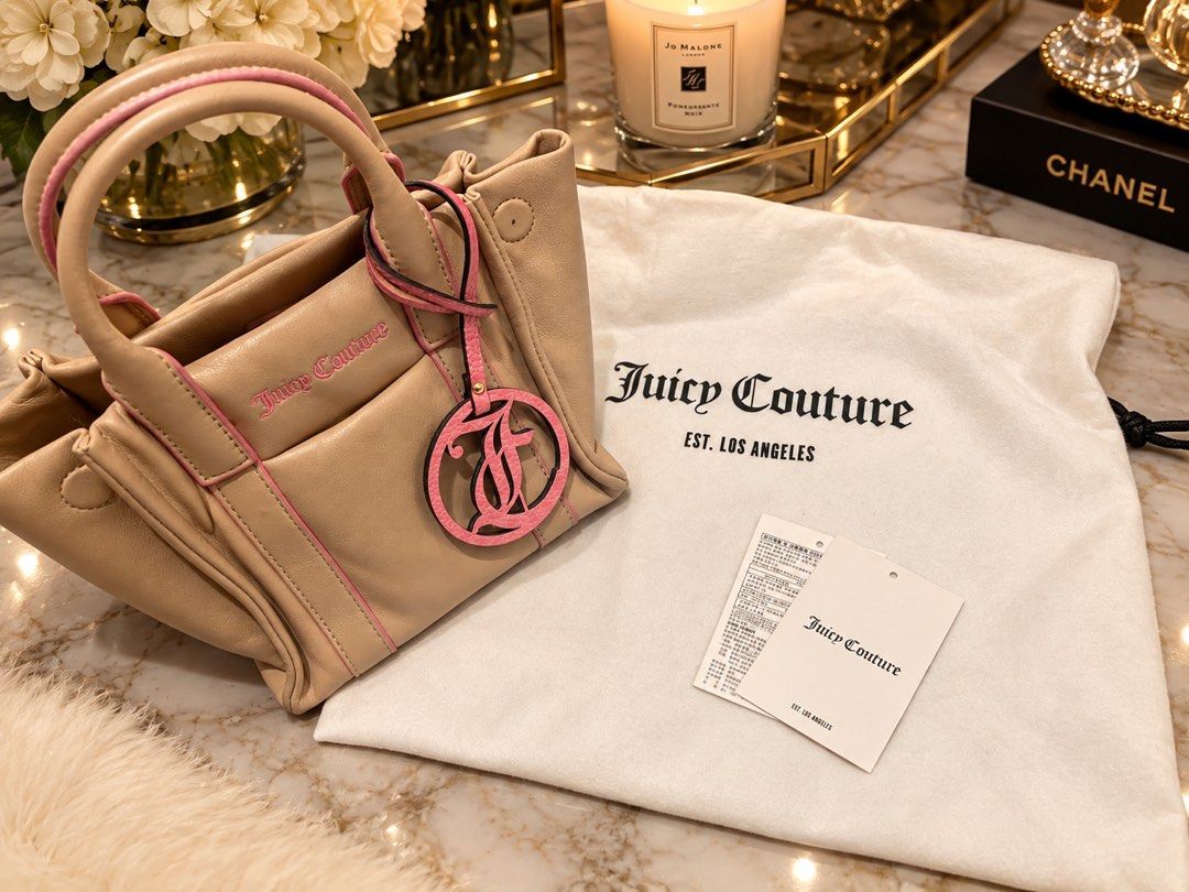 Juicy Couture (Category: Luxury Bags & Wallets) located in Pasig City. Submitted by hicupqueen (Listing ID 1462710122, Image 1). Description: Brand: Juicy Couture Color: Beige with pink trim Style: Mini tote bag Features: Matching 'JC' charm Condition: Comes with original dust bag and tags Use: Perfect for carrying essentials and quick outings Note: 14,000+ sa JC Boutique sa Greenbelt. From 🇰🇷 Decluttering .