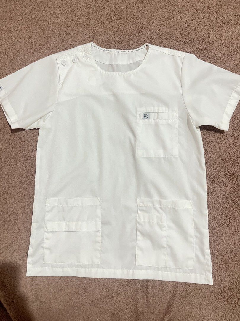 Kaizen White Scrub suit (Category: Sets & Coordinates) located in Baguio. Submitted by mikachuuu368 (Listing ID 1462842593, Image 2). Description: Kaizen Scrub suit - 3 button overlap • Size small - check sizing guide posted TOP: • Functional 3-button overlap shoulder opening • Round Neck design • 1 Welt chest pocket • 2 Patch waist pockets • 1 waist secret pocket • 1 waist pen pocket PANTS: • 2 Insert front pockets • 1 Fake button fly • 2 Patch 