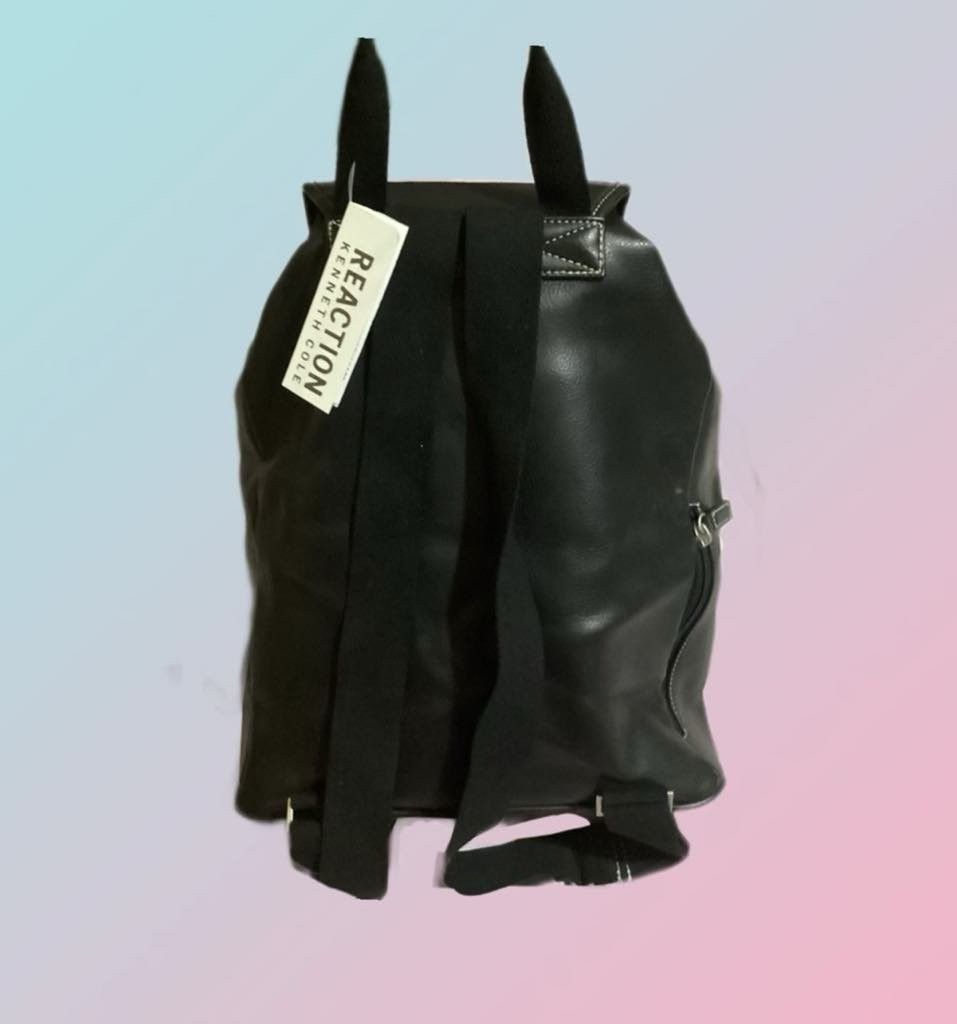 Kenneth Cole REACTION back pack (Category: Backpacks) located in Paranaque City. Submitted by calm_youngstore7 (Listing ID 1462813048, Image 3). Description: Kenneth Cole REACTION black faux-leather backpack featuring a classic drawstring main compartment under a magnetic flap closure and a distinctive silver square buckle accent. This specific design features a clean horizontal zippered pocket on the front lower body and a debossed "REACTION KEN