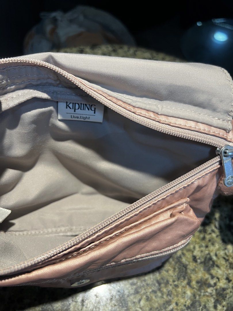 Kipling Rose Gold Nylon Waist Bag with Monkey Charm (Category: Purses & Pouches) located in Manila. Submitted by kathlv (Listing ID 1462827551, Image 3). Description: - Cute Kipling waist bag in shimmery rose gold. - Made from durable nylon. - Features a main zippered compartment and a front zippered pocket. - Comes with the iconic Kipling monkey charm. - Adjustable strap for a comfortable fit. - Ideal for travel or everyday use..