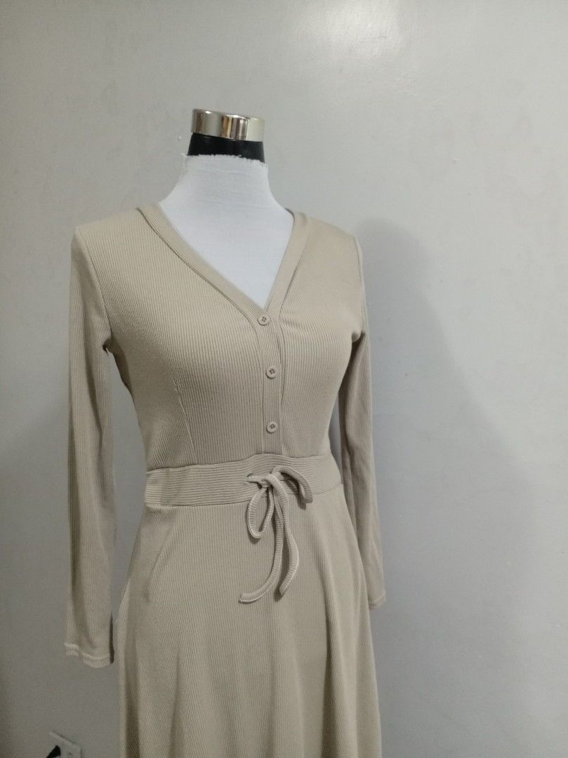 Knitted long dress (Category: Dresses) located in Paranaque City. Submitted by janella11 (Listing ID 1462684332, Image 3). Description: - Ribbed midi dress in a versatile beige color. - Features long sleeves and a stylish button-front design. - Includes a tie belt to customize your fit and cinch the waist. - Elegant flounce hem for a flattering silhouette. - Ideal for both casual outings and dressing up for occasions..