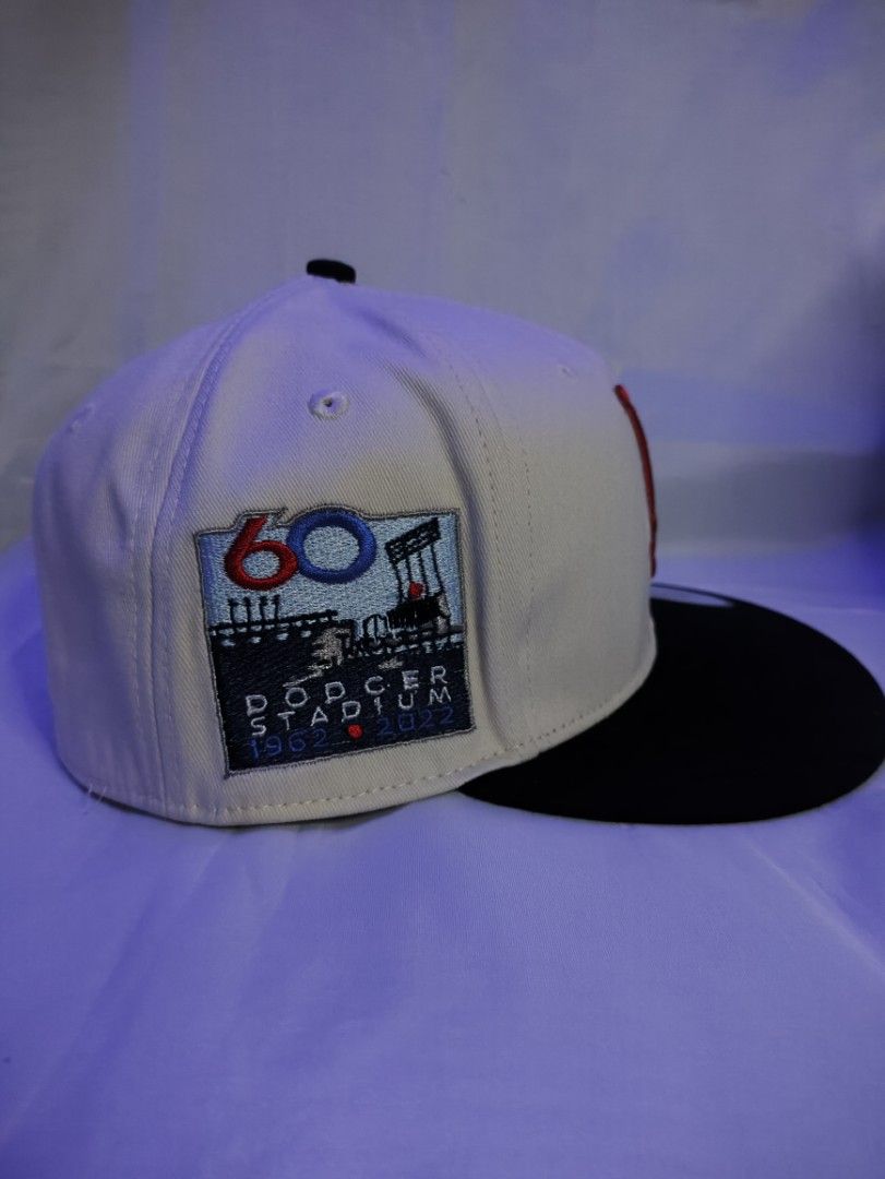 LA Dodgers Snapback Cap - Dodger Stadium 60th Anniversary (Category: Caps & Hats) located in Manila. Submitted by vestige_collection (Listing ID 1462863979, Image 2). Description: - LA Dodgers snapback hat - Cream colored crown with red 'LA' logo - Black brim - Special patch: Dodger Stadium 60th Anniversary (1962-2022) - MLB logo on the back - Adjustable snapback closure - Size: 7 1/8.