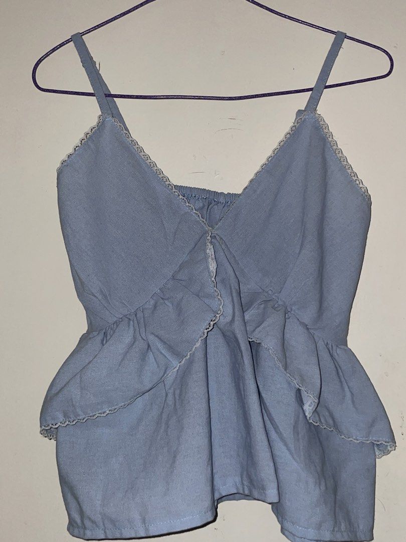 Light Blue Ruffled Camisole Top with Adjustable Straps (Category: Sleeveless) located in Manila. Submitted by sammmm777 (Listing ID 1462768958, Image 1). Description: - 32A-34B bust - Adorable light blue camisole top - Features charming ruffles on neckline and hem - Garterized back ensures a snug and comfortable fit - Adjustable straps for a customized fit - Versatile piece for casual outings or dressing up.