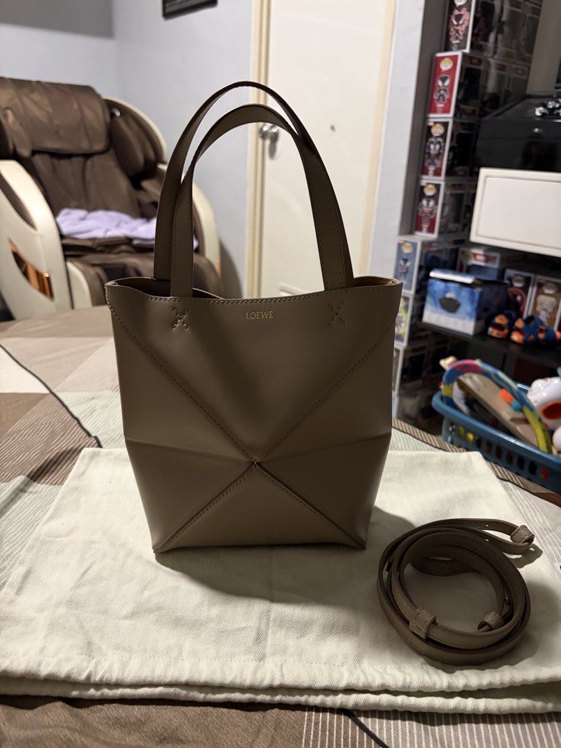 LOEWE Puzzle Fold Mini Bag Sand Color (Category: Tote Bags) located in Cavite. Submitted by tripleKgels (Listing ID 1462870195, Image 1). Description: - Loewe Puzzli Fold Tote Bag - Color: Taupe/Sand - Material: Leather - Features: Detachable shoulder strap, unique folded design - Versatile: Ideal for daily use or special occasions.
