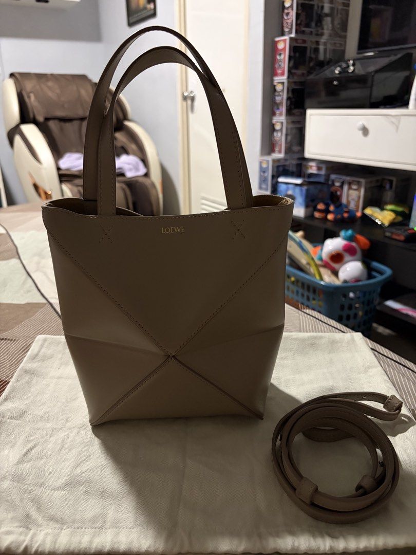 LOEWE Puzzle Fold Mini Bag Sand Color (Category: Tote Bags) located in Cavite. Submitted by tripleKgels (Listing ID 1462870195, Image 3). Description: - Loewe Puzzli Fold Tote Bag - Color: Taupe/Sand - Material: Leather - Features: Detachable shoulder strap, unique folded design - Versatile: Ideal for daily use or special occasions.