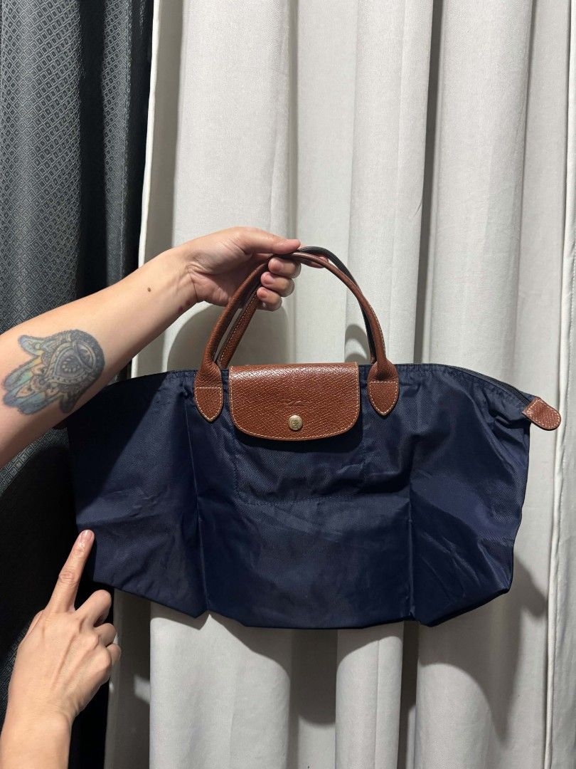 Longchamp Le Pliage Cuir Small Top Handle Bag Navy (Category: Luxury Bags & Wallets) located in Manila. Submitted by mariecunan80818 (Listing ID 1462794837, Image 3). Description: - Classic Longchamp handbag in navy blue - Durable nylon with leather trim - Snap button closure on flap and zip top - Interior small pocket - Folds flat for easy storage - Comfortable handles - Ideal for everyday use or travel.