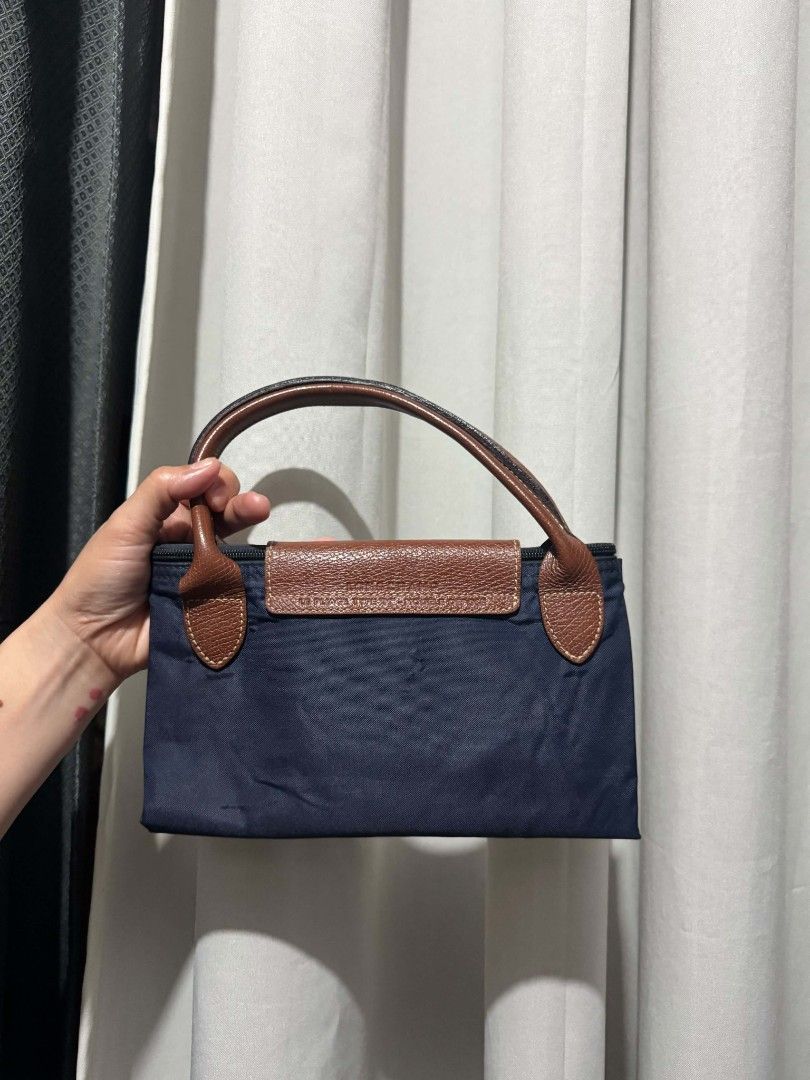 Longchamp Le Pliage Cuir Small Top Handle Bag Navy (Category: Luxury Bags & Wallets) located in Manila. Submitted by mariecunan80818 (Listing ID 1462794837, Image 2). Description: - Classic Longchamp handbag in navy blue - Durable nylon with leather trim - Snap button closure on flap and zip top - Interior small pocket - Folds flat for easy storage - Comfortable handles - Ideal for everyday use or travel.