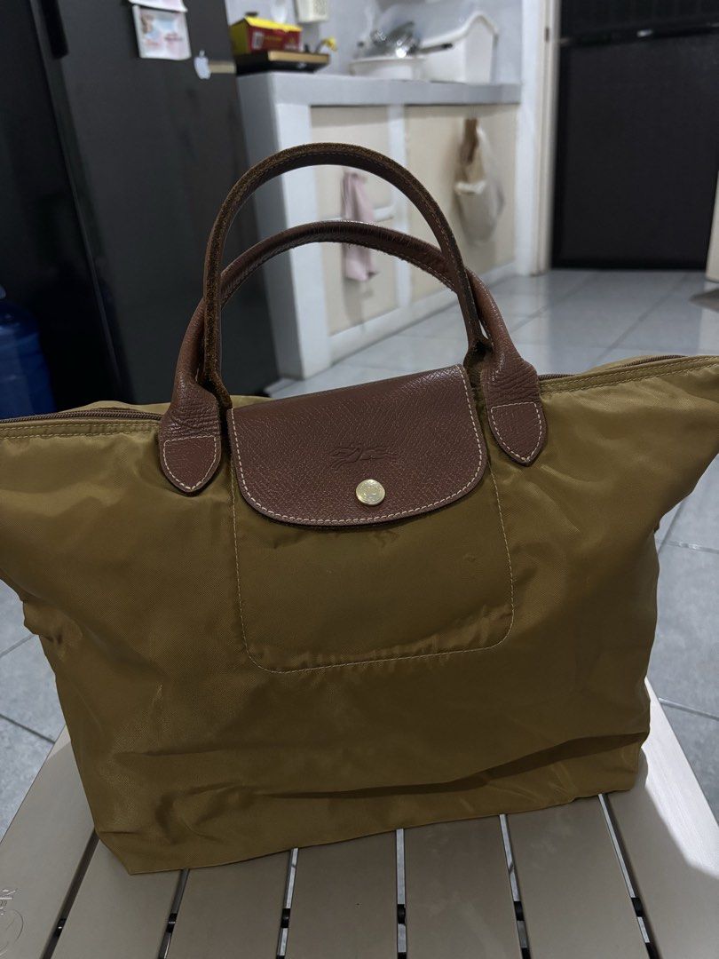 Longchamp Le Pliage Tote Bag (Category: Luxury Bags & Wallets) located in Manila. Submitted by lai.p (Listing ID 1462780063, Image 2). Description: - Authentic Longchamp tote bag - Color: Olive green nylon with brown leather handles and trim - Spacious main compartment - Convenient front pocket - Ideal for travel or everyday use - Folds flat for easy storage.