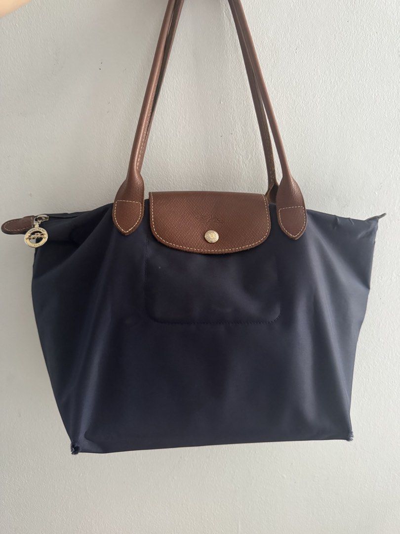Longchamp Le Pliage Tote Bag Navy Blue (Category: Luxury Bags & Wallets) located in Manila. Submitted by decluterthings888 (Listing ID 1462706548, Image 3). Description: - Classic Longchamp Le Pliage tote bag - Color: Navy blue nylon with brown leather handles and trim - Closure: Snap closure - Interior: One interior pocket - Perfect for: Everyday use, travel, carry-on.