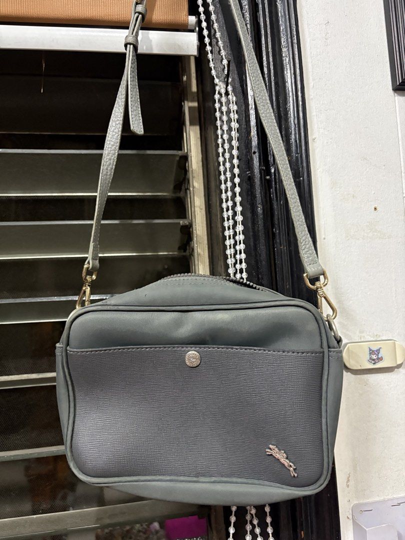 Longchamp Paris Grey Leather Crossbody Bag (Category: Cross-body Bags) located in Makati City. Submitted by cherriesforme (Listing ID 1462843779, Image 1). Description: - Authentic Longchamp Paris crossbody bag in grey. - Crafted from premium leather. - Textured front pocket for added detail. - Secure main zippered compartment. - Convenient interior slip pockets. - Adjustable strap for comfortable wear. (Replaced) - Subtle metal logo detail on th