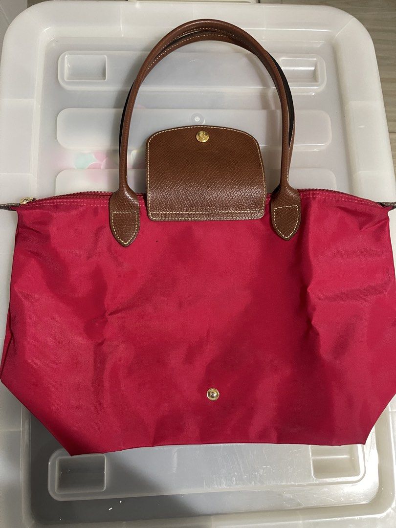 Longchamp Paris Red Nylon Tote Bag (Category: Luxury Bags & Wallets) located in Paranaque City. Submitted by alexagamboa (Listing ID 1462825712, Image 3). Description: - Red Longchamp tote bag - Made in China - Genuine leather handles and trim - Secure zipper closure with snap button flap - Very spacious, ideal for everyday essentials - A great everyday carry-all!.