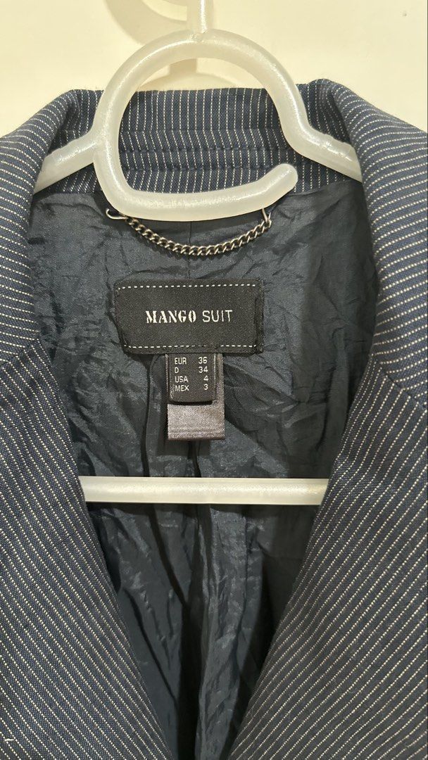 Mango Suit Navy Pinstripe Blazer (Category: Coats, Jackets and Outerwear) located in Mandaluyong City. Submitted by yv.stuff (Listing ID 1462768049, Image 2). Description: - Navy blue blazer from Mango Suit - Classic pinstripe pattern - Single-breasted with a two-button front - Stylish peplum detail at the waist - Ideal for workwear or smart casual outfits - Refer to label for exact sizing.