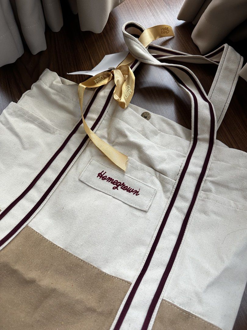 Mary Grace Homegrown totebag (Category: Tote Bags) located in Manila. Submitted by lovedbytone (Listing ID 1462723580, Image 3). Description: - 'Homegrown' embroidered canvas tote bag - Burgundy stripes on handles and sides - Convenient outer pockets - Secure button closure - Comes with original tags and ribbon - Ideal for everyday use.