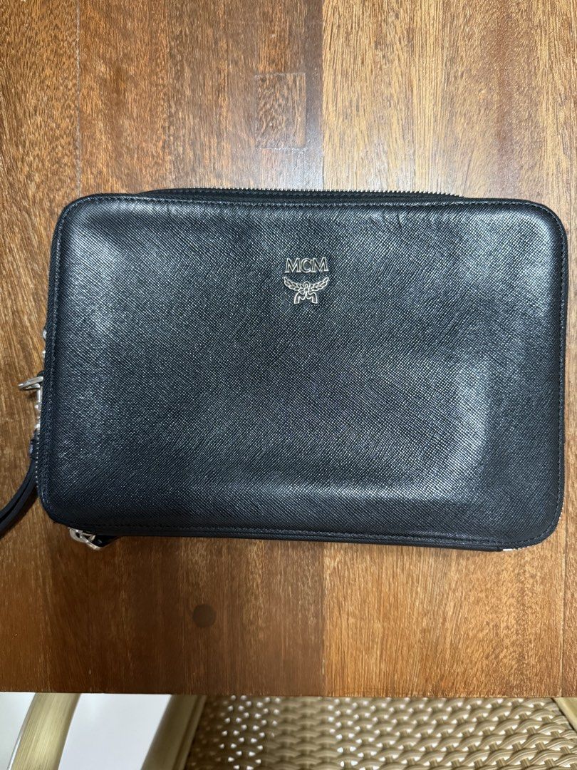 MCM Black Leather Clutch bag (Category: Luxury Bags & Wallets) located in Pasig City. Submitted by Mg91___ (Listing ID 1462701329, Image 1). Description: - Authentic MCM clutch wallet - Black leather with signature monogram pattern inside - Multiple card slots and compartments for organization - Secure zipper closure - Ideal for carrying your essentials - Guaranteed Authentic or money back.