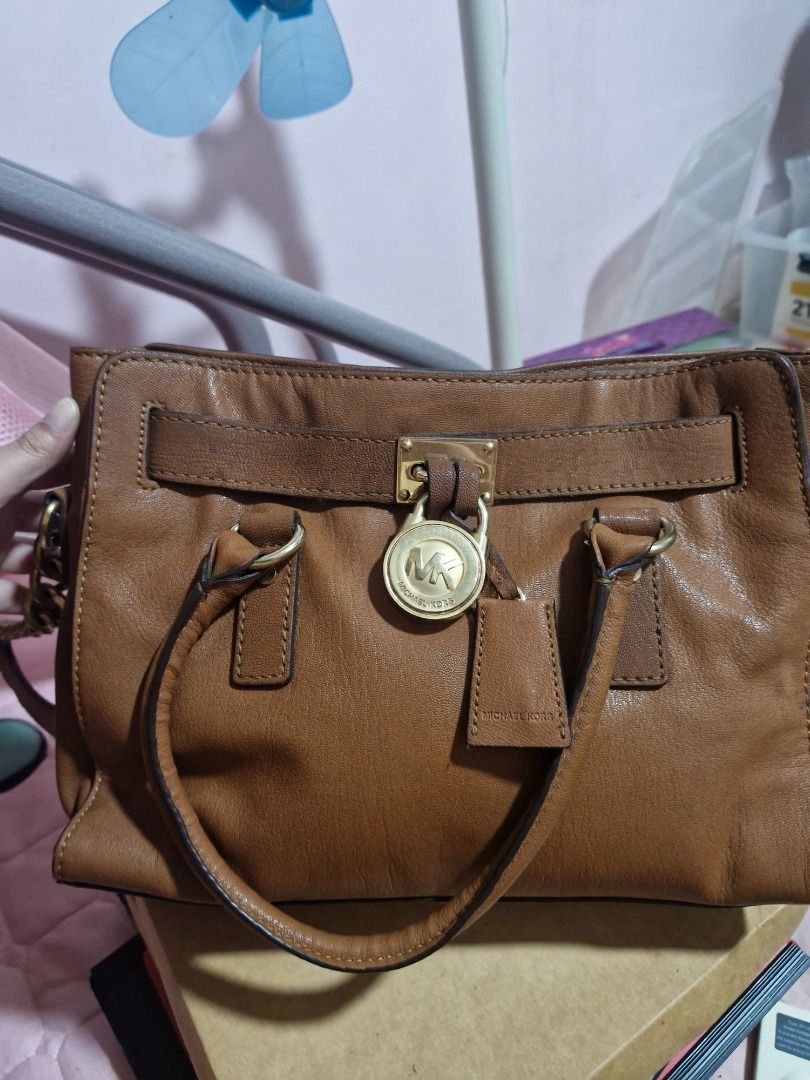Michael Kors Brown Leather Satchel Handbag (Category: Luxury Bags & Wallets) located in Makati City. Submitted by checatan000888 (Listing ID 1462727714, Image 1). Description: - Genuine brown leather Michael Kors satchel - Versatile with top handles and a detachable shoulder strap - Elegant gold hardware with signature MK logo lock - Spacious interior with a zip pocket and slip pockets - Clean and well-maintained interior - Ideal everyday bag for