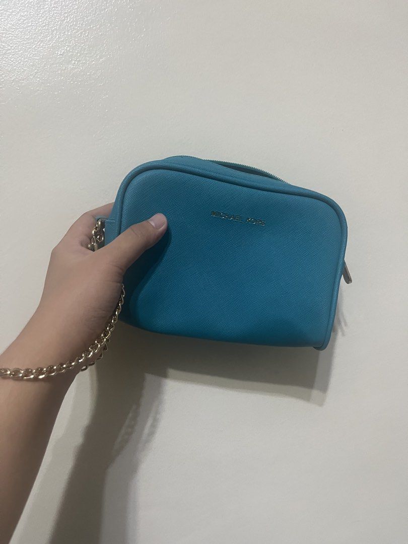 Michael Kors Teal Small Chain Pouch – Preloved (Category: Luxury Bags & Wallets) located in Manila. Submitted by brightshark-0d45dd (Listing ID 1462767399, Image 1). Description: - Blue/Teal Michael Kors cosmetic bag - Genuine Saffiano leather - Chic gold chain strap - Secure zipper closure - Interior pocket for organization - Ideal for makeup and small essentials - Compact size, fits easily in larger bags No receipt/inside tag available..