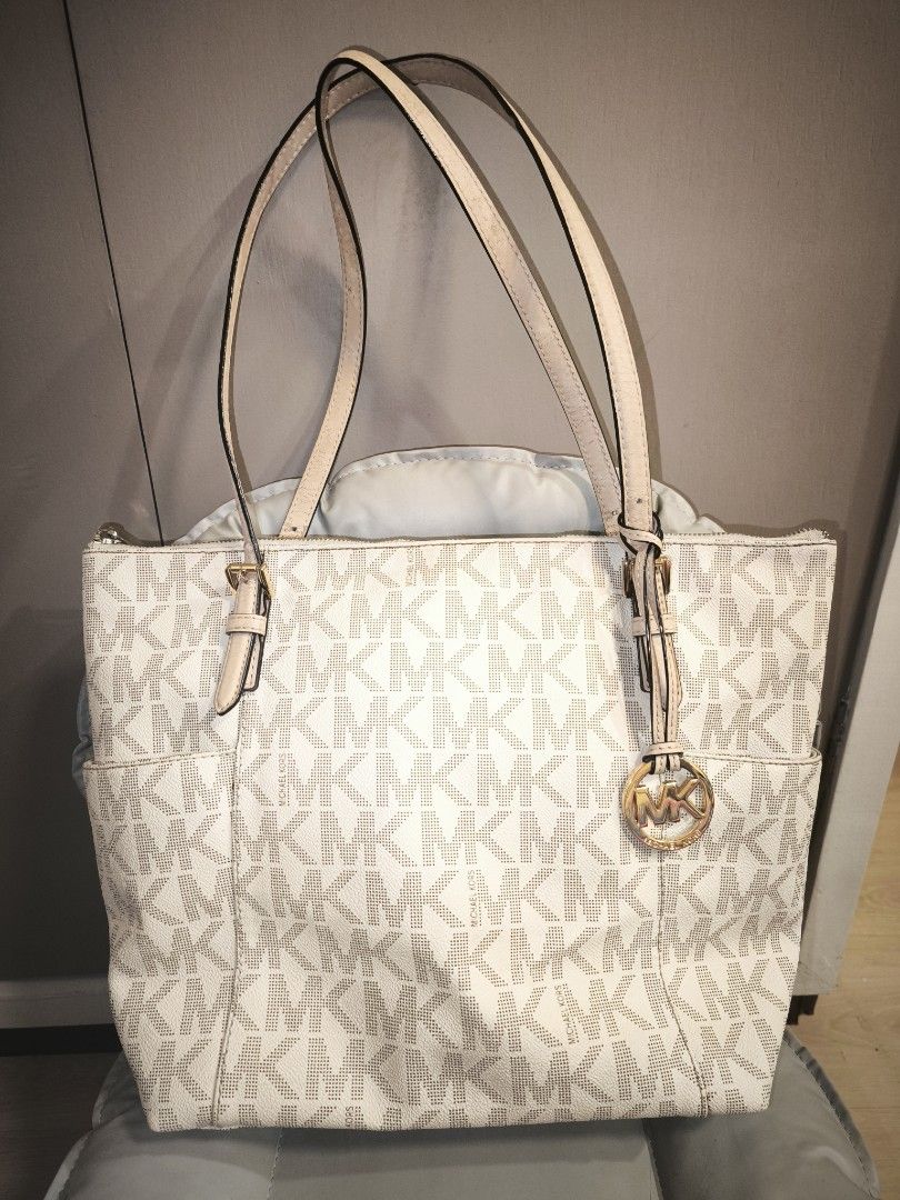 Michael Kors White Monogram Tote Bag (Category: Luxury Bags & Wallets) located in Baguio. Submitted by zia_zab (Listing ID 1462820559, Image 1). Description: - Authentic Michael Kors tote bag - Classic white with signature MK monogram print - Beige leather straps and trim - Elegant gold-tone hardware with MK charm - Secure zipper closure - Convenient exterior side pockets - Ample interior space for all your essentials - Ideal for daily use Dimes: