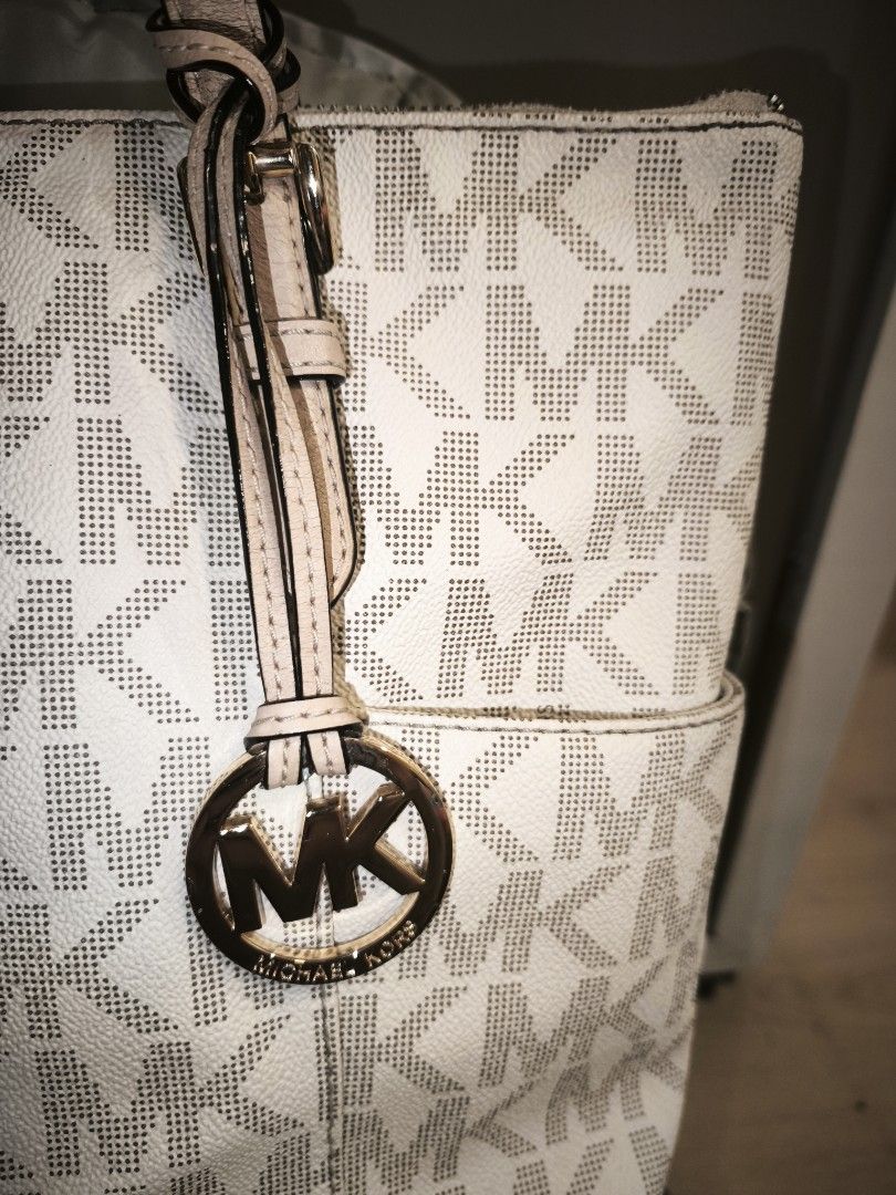 Michael Kors White Monogram Tote Bag (Category: Luxury Bags & Wallets) located in Baguio. Submitted by zia_zab (Listing ID 1462820559, Image 3). Description: - Authentic Michael Kors tote bag - Classic white with signature MK monogram print - Beige leather straps and trim - Elegant gold-tone hardware with MK charm - Secure zipper closure - Convenient exterior side pockets - Ample interior space for all your essentials - Ideal for daily use Dimes: