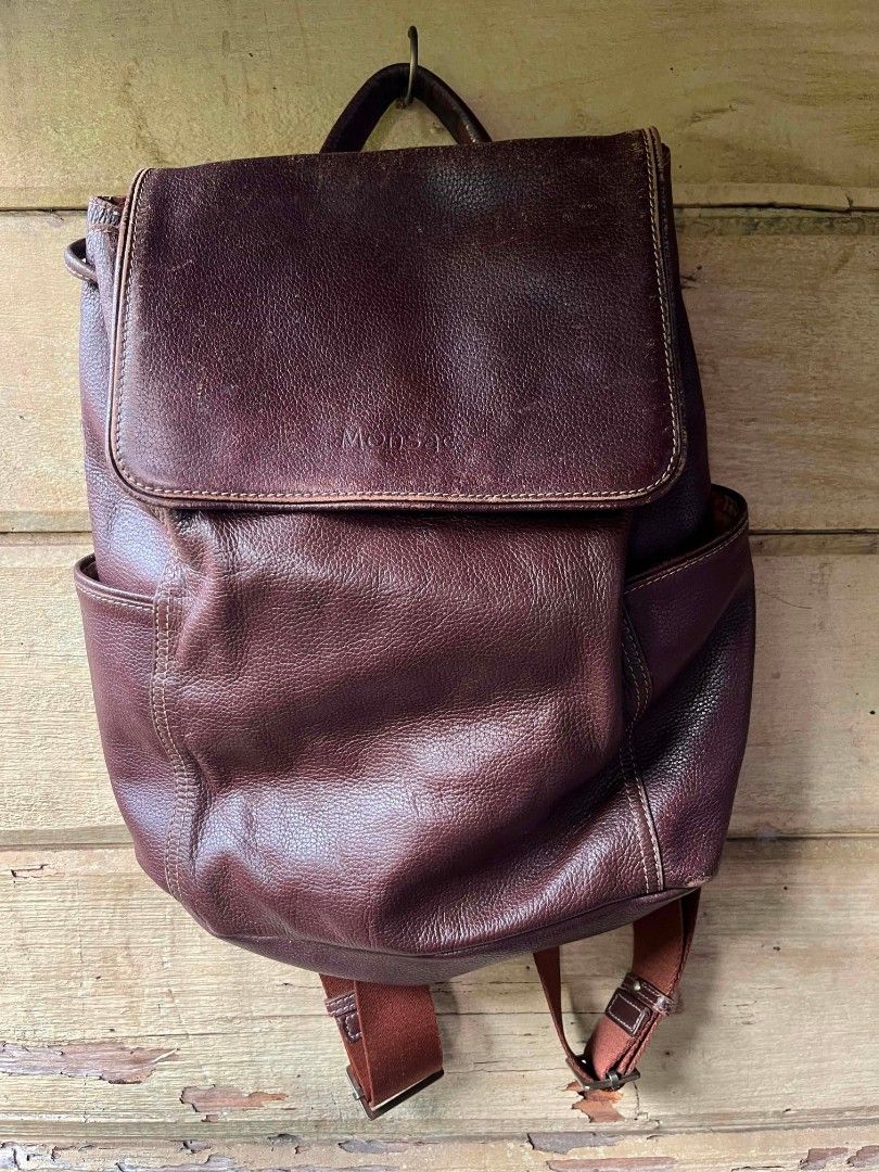 Monsac Leather Backpack - Burgundy (Category: Backpacks) located in Baroy. Submitted by laudecarlfe24 (Listing ID 1462790970, Image 1). Description: - Burgundy leather backpack from Monsac - Flap closure with drawstring underneath - Two side pockets - Zippered pocket on the back - Interior with striped lining - Adjustable straps - Shows some signs of wear on the leather, consistent with a used item.